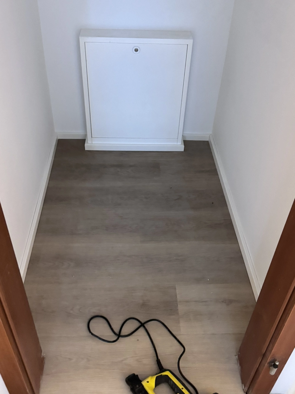Kleiner Flur mit neu verlegtem Laminatboden und Wartungsklappe an der Rückwand – Laminat verlegen