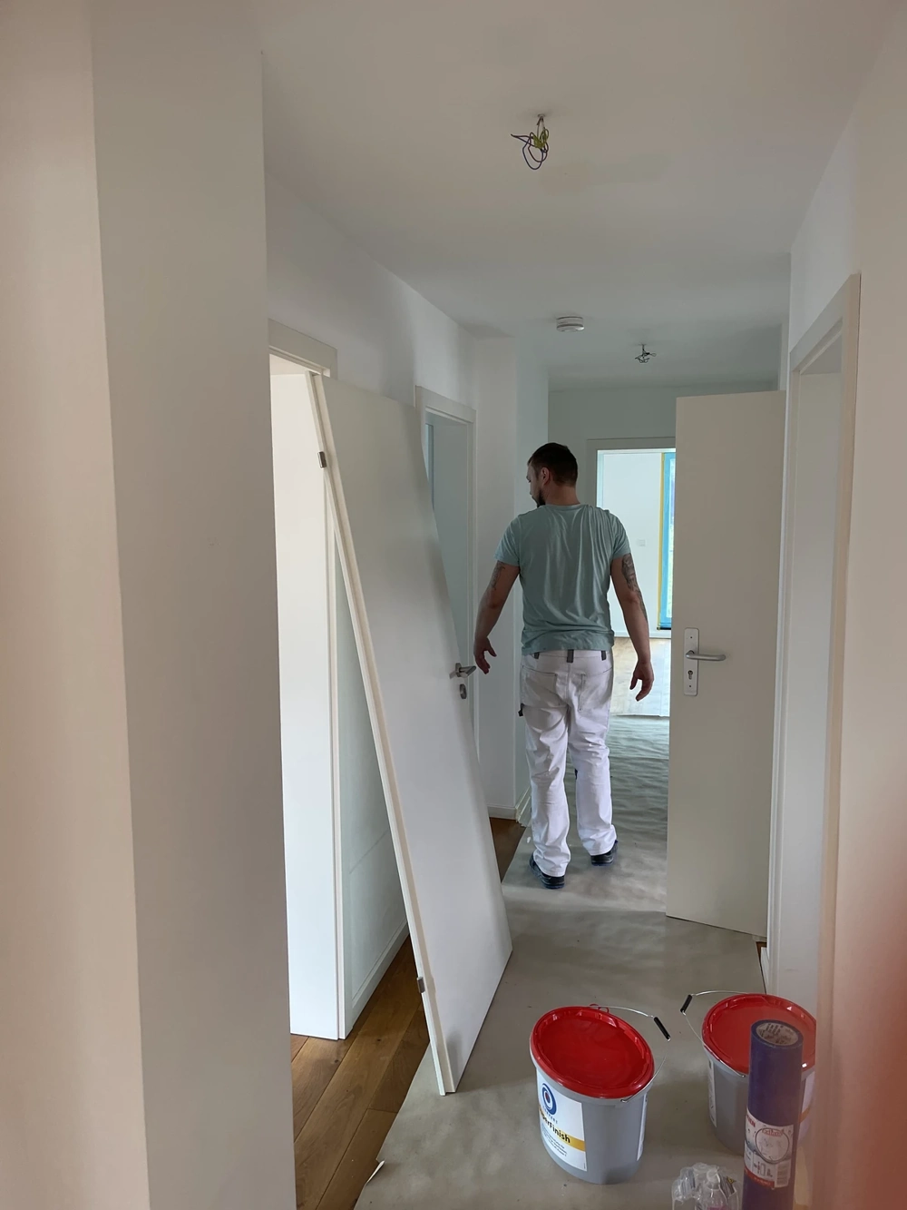 Instalacja drzwi wewnętrznych w korytarzu mieszkania podczas prac remontowych