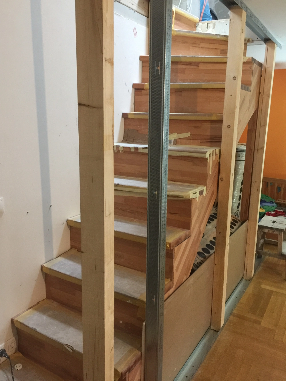 Trockenbau-Installation mit Metallprofilen und teilverkleideter Holztreppe im Innenausbau