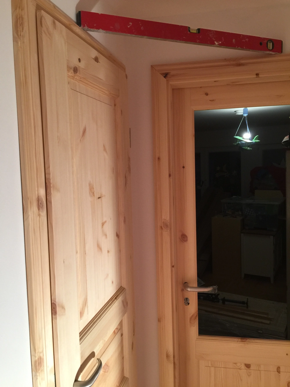 Einbau einer Holz-Innentür mit Rahmen und Wasserwaage im Flur